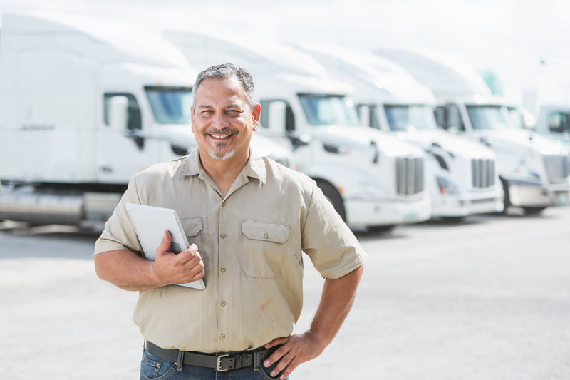 man standing in front of a row of trucks