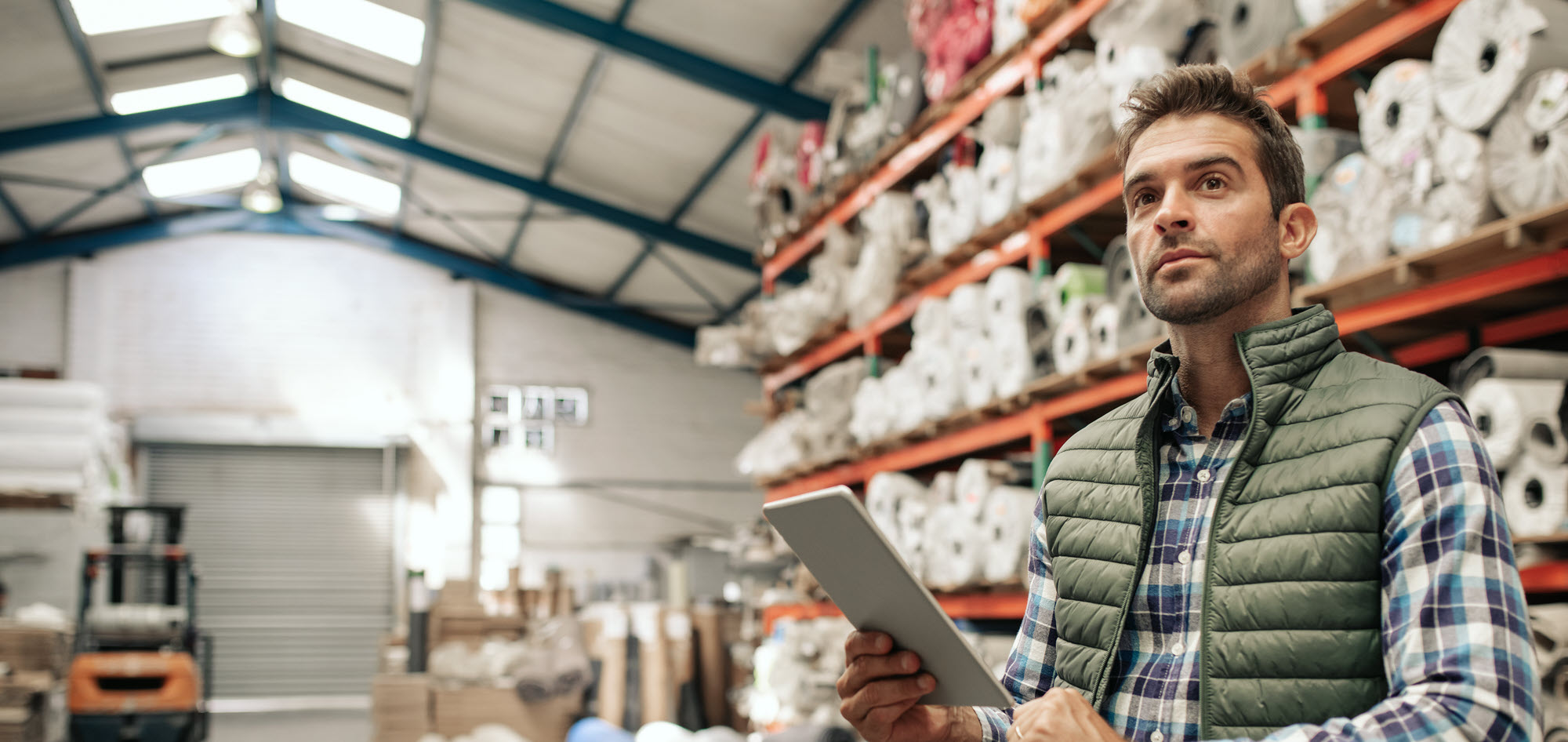 man in a warehouse with an ipad