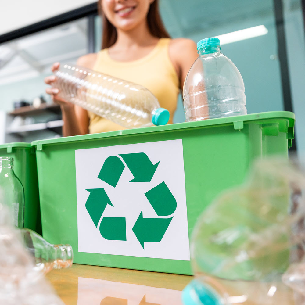woman putting a water bottle into a recycling bin